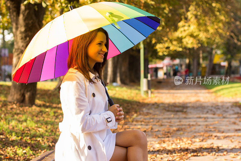 黑发女孩在森林里拿着五颜六色的雨伞