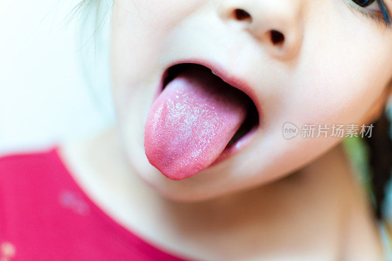 小女孩伸出她的舌头