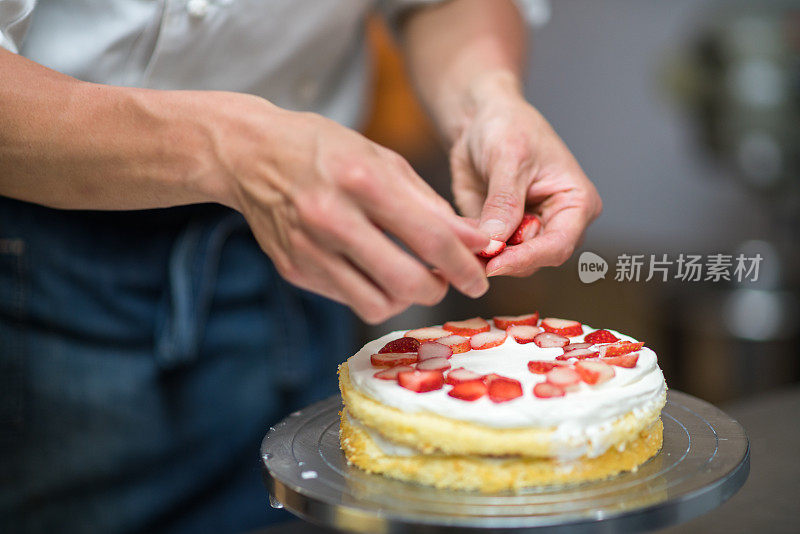 面包师把草莓放在蛋糕层之间