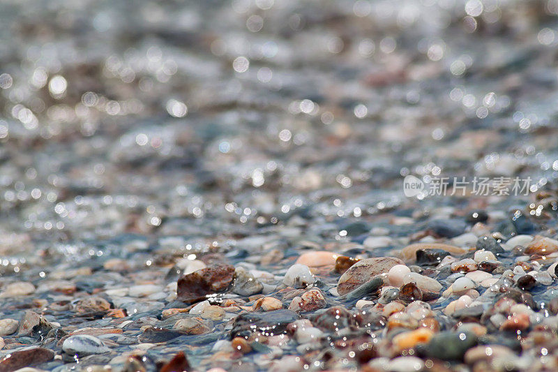 潮湿的卵石在海滩上铺开