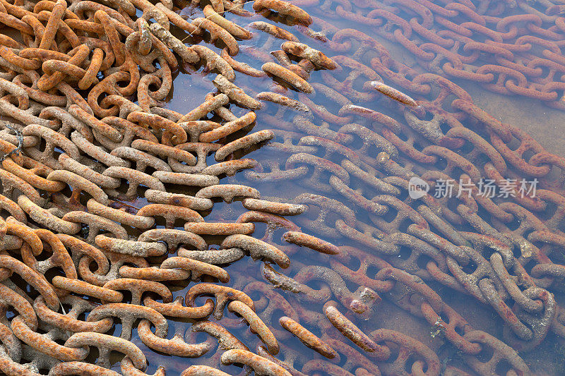 工业船厂在海水中铺设生锈的金属链