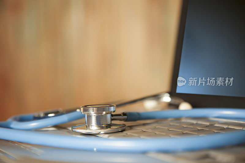 医生的听诊器在笔记本电脑键盘上。