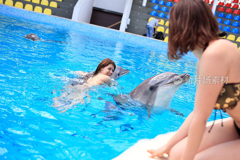 海豚翻滚着一个年轻的女人