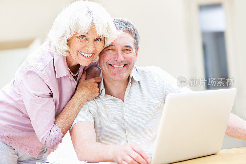 带着笔记本电脑微笑的老年夫妇