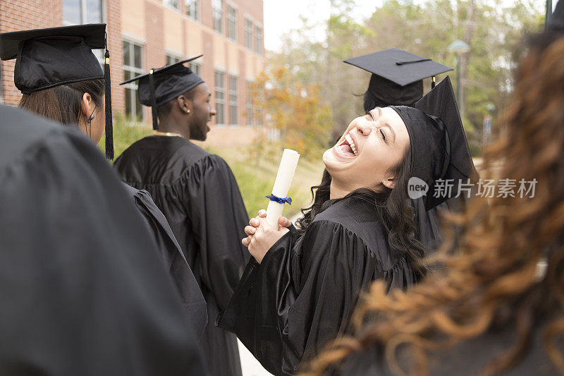 教育:兴奋的混血儿毕业生和朋友在大学校园。