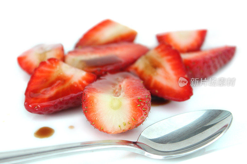 草莓切片配香醋，糖，勺子，健康的甜点