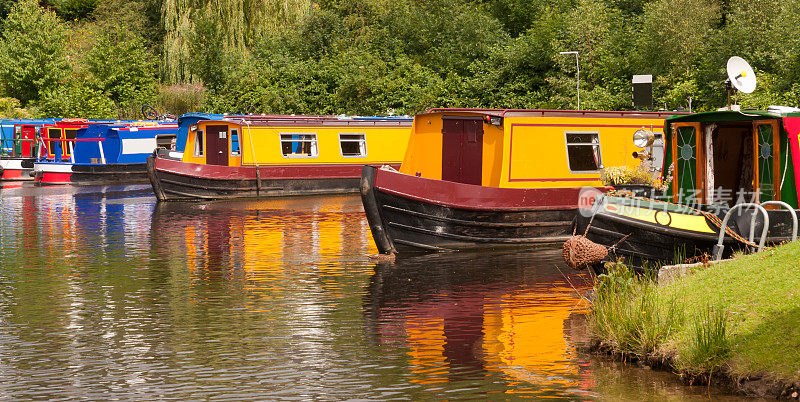 假日运河船停靠在英国乡村的运河上。