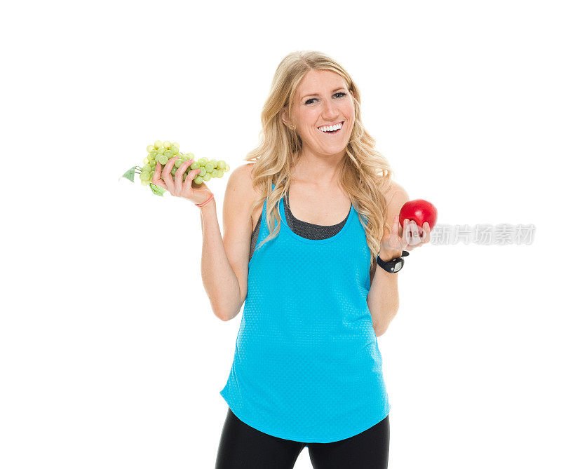 微笑的女运动员拿着水果