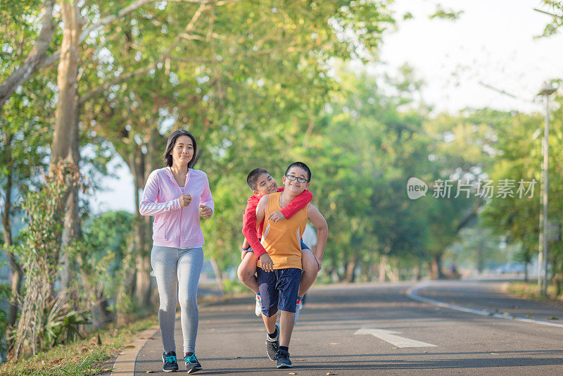 家庭运动快乐活跃的母亲和孩子在户外慢跑，在森林里跑步