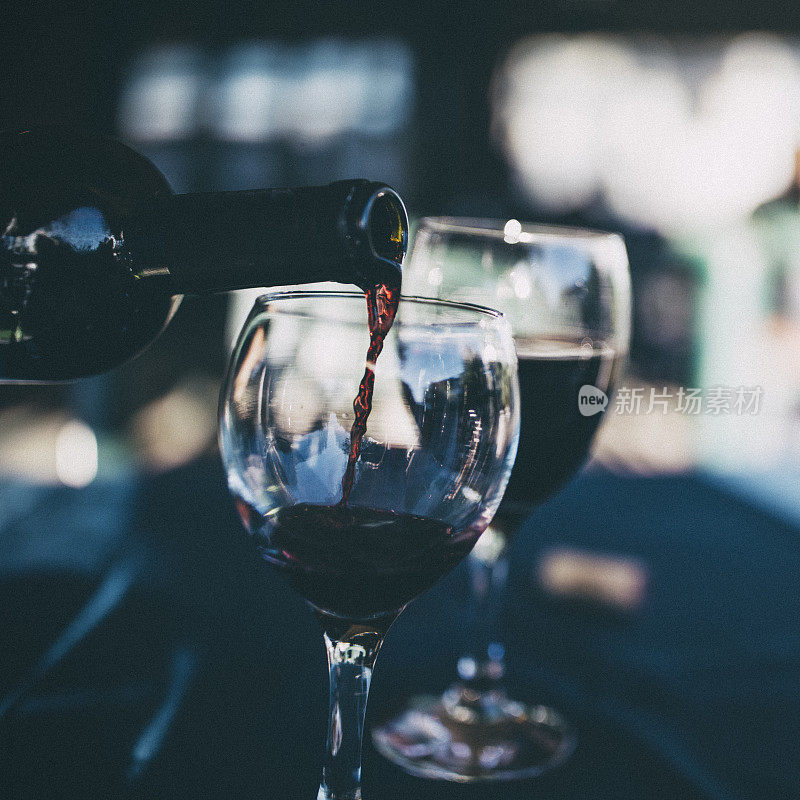 红酒被倒入玻璃杯的特写镜头。