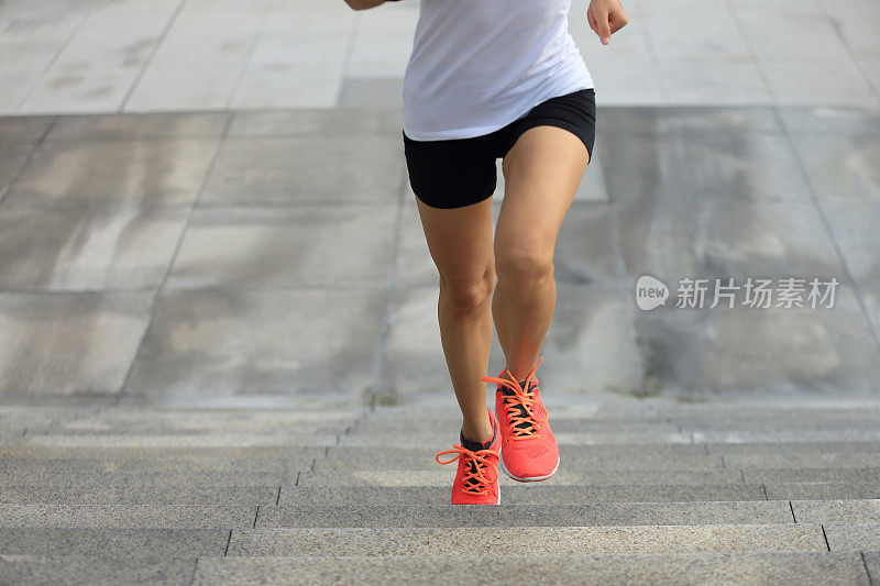 年轻的女运动员在城市的楼梯上奔跑