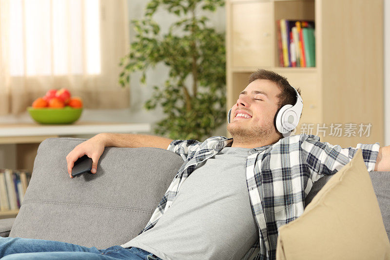 放松的男人在家里听音乐