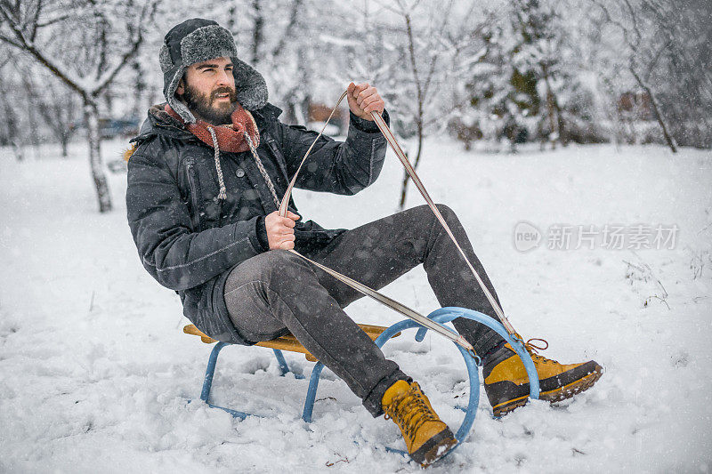 在滑雪胜地滑雪橇的英俊男子