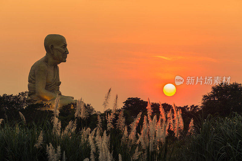 傍晚橙色的日落和景观与大雕像