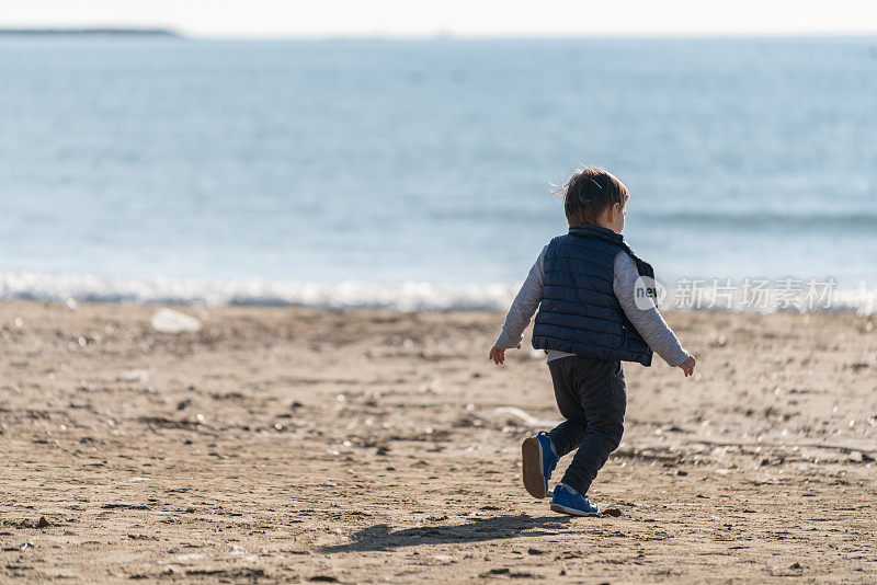 小男孩在海滩上跑步