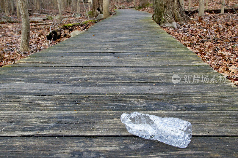 废弃的塑料水瓶在木板人行道上