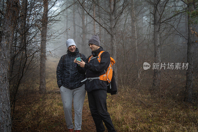 在雾蒙蒙的森林里的徒步旅行者