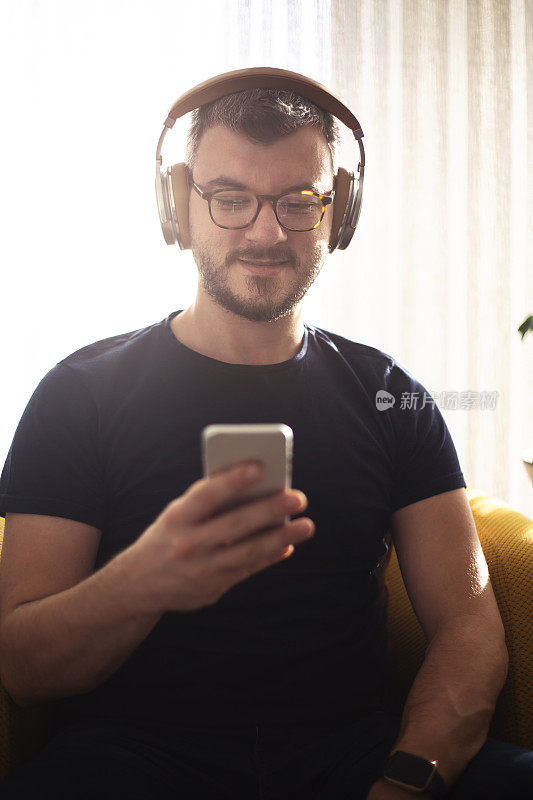 年轻人用耳机和智能手机听音乐
