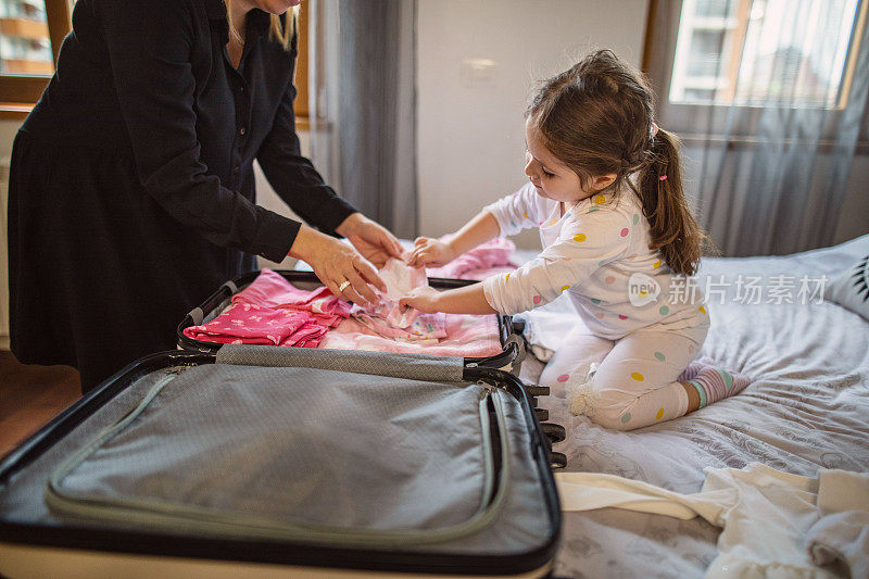 小女孩在帮妈妈收拾行李