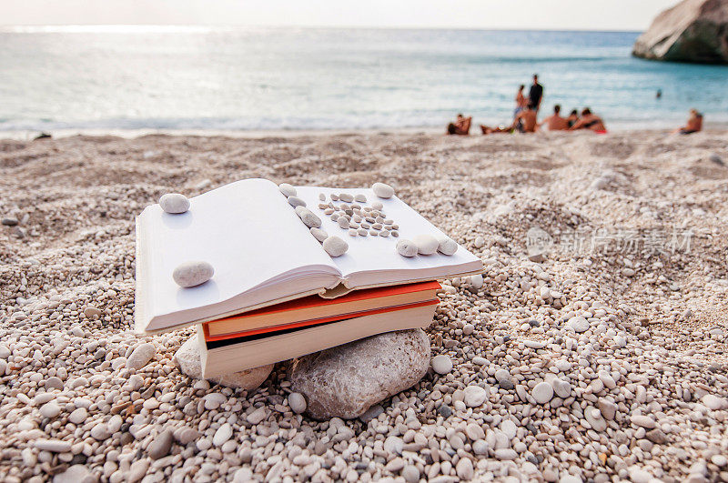 夏日阅读――在沙滩上看书，有人做背景