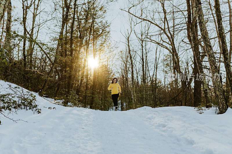 女人在雪地上蹦蹦跳跳