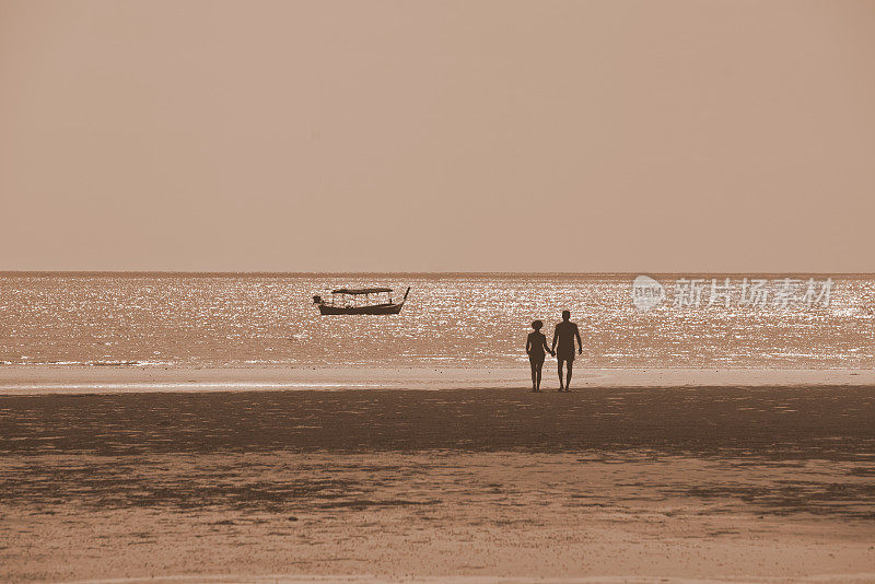 日落时分，帕卡朗海滩上的一对老年夫妇