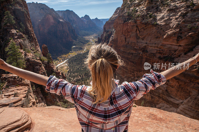 女孩在山谷上张开双臂;女人徒步旅行