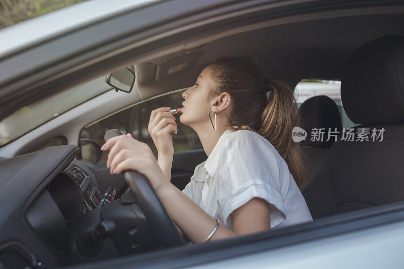 小女孩在雨天堵车的路上涂口红