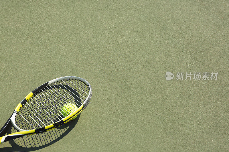 硬地下面的网球和球拍