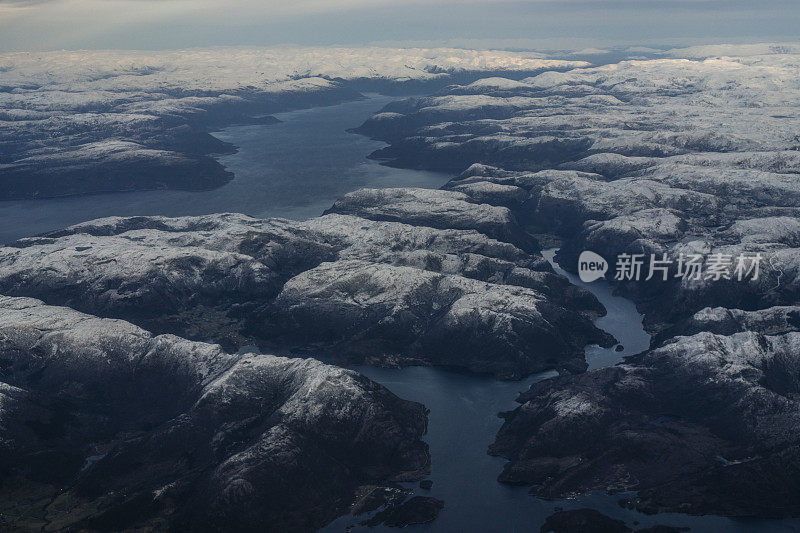 乘客从飞机上俯瞰挪威的峡湾，山上覆盖着积雪