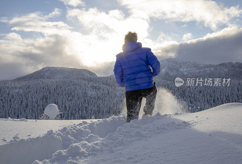 人类穿过厚厚的粉状雪走向冉冉升起的太阳