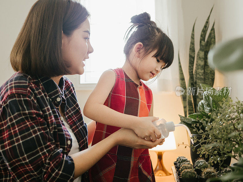 时髦的母亲和女儿照顾植物