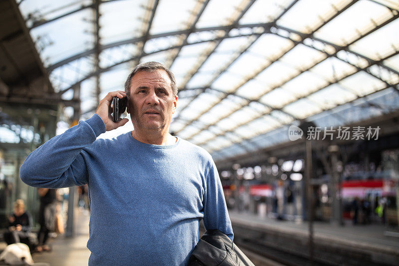 游客在科隆中央车站等火车时使用手机