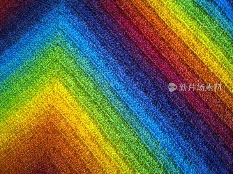 抽象毛织背景。彩虹的颜色梯度:酒红色，深红色，橙色，黄色，绿色，经典的蓝色，紫色，蓝莓。艺术几何学之美。菱形和对角线。