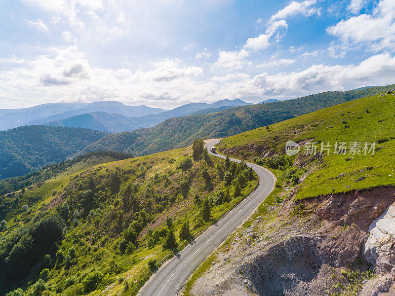 鸟瞰图追逐一辆卡车和两辆汽车的山路与美丽的森林