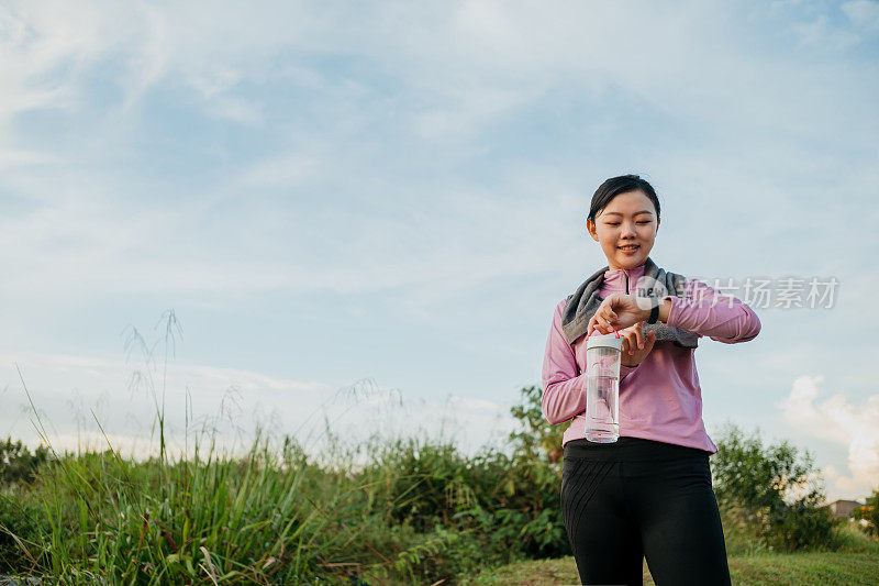 运动亚洲女性检查智能手表后的心率