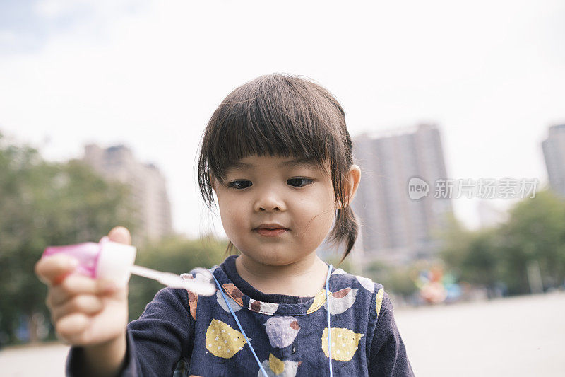 中国小女孩在公园里吹泡泡