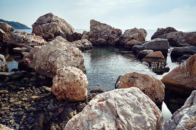 地中海岩石海岸。大石头和鹅卵石