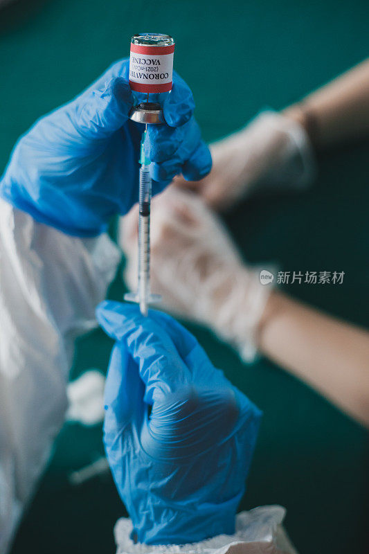 护士手戴手术手套为患者准备COVID-19疫苗
