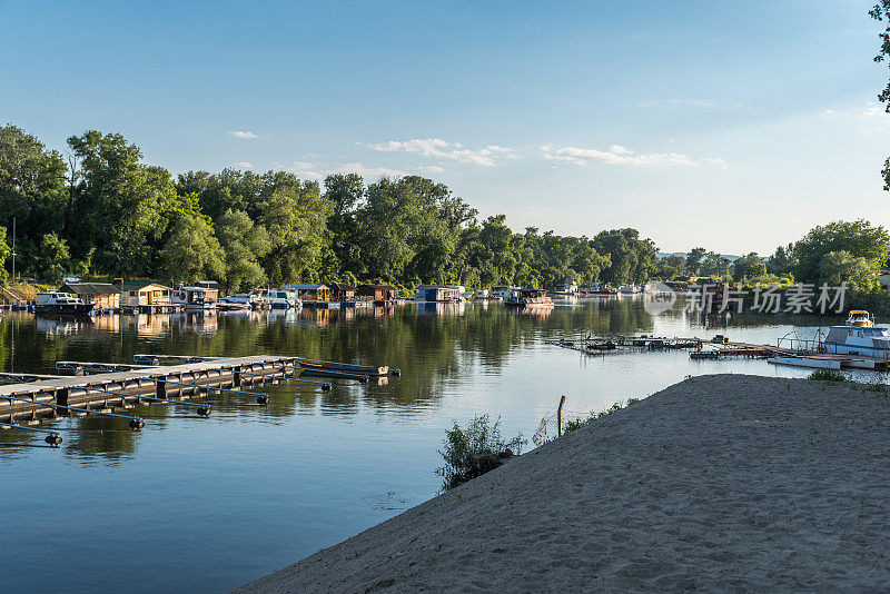 一个浮动的避暑别墅的观点，旨在为夏季假期的泊位和码头上的船只和快艇的水面上的河流或湖泊