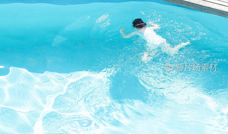 孩子在室外游泳池里洗澡。湛蓝清澈的池水。