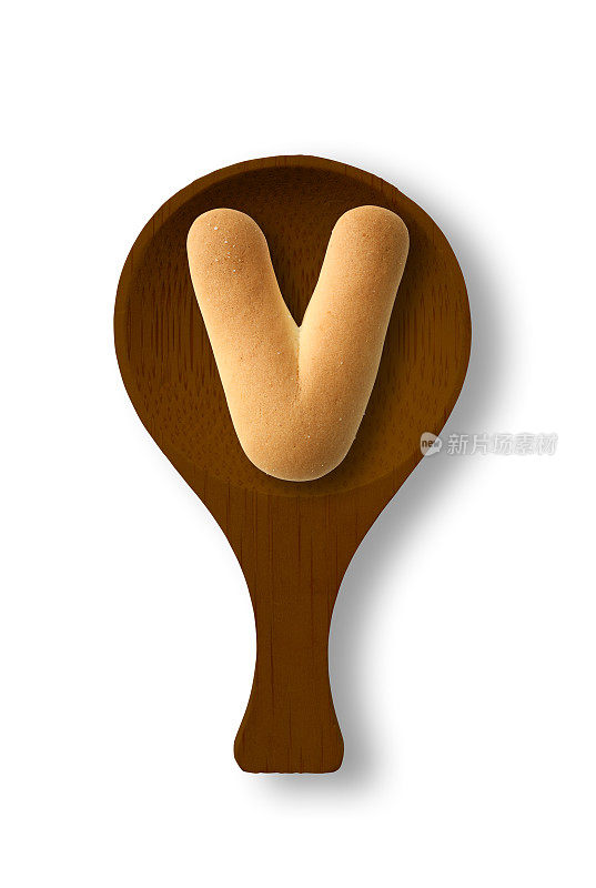 孤立的照片的大写字母饼干V上的木勺，在白色的背景