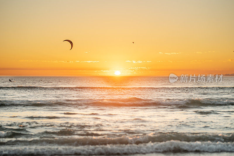 在夏天的日落时分，玩风筝冲浪