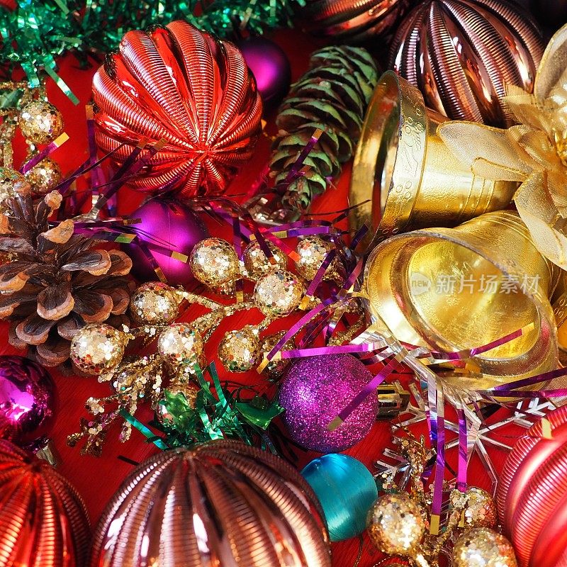 圣诞背景用圣诞装饰物，节日球、铃铛、蝴蝶结、冷杉锥、圣诞树雨。新年快乐，圣诞快乐。红色，棕色，条纹，绿色，金色，紫色，五颜六色的装饰