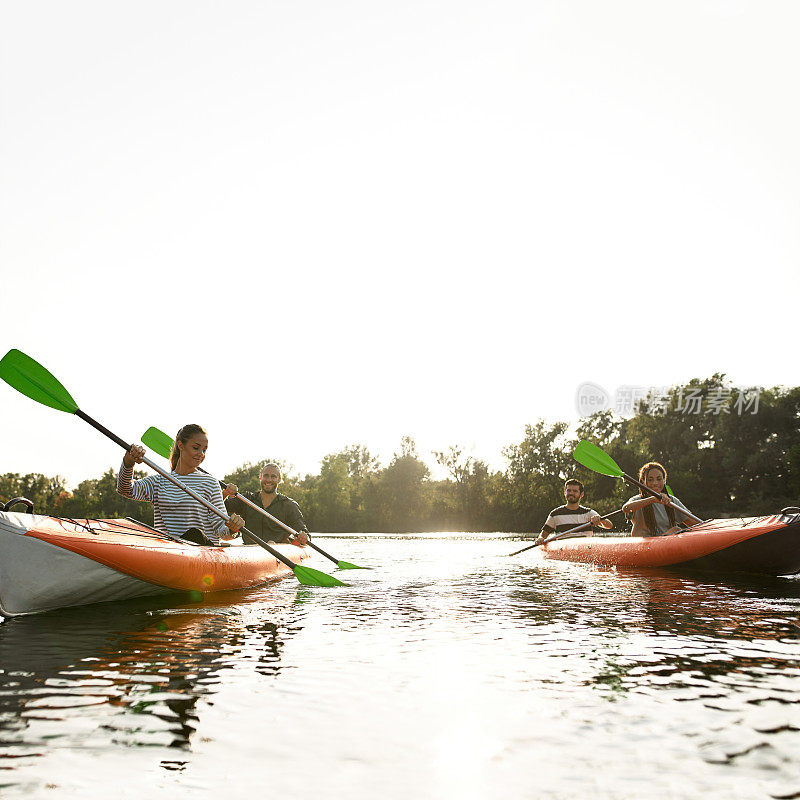 不安分的年轻朋友们一起在河上划皮艇，在夏天的一天在户外度过周末