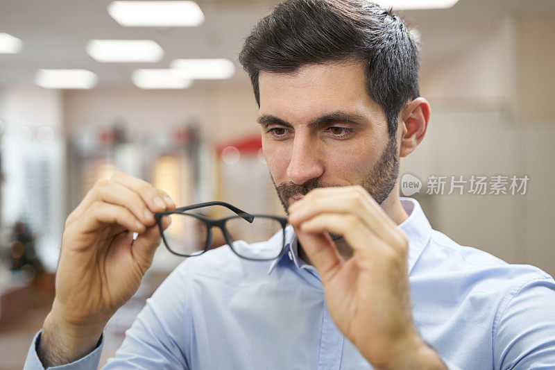 男顾客在眼镜店检查眼镜
