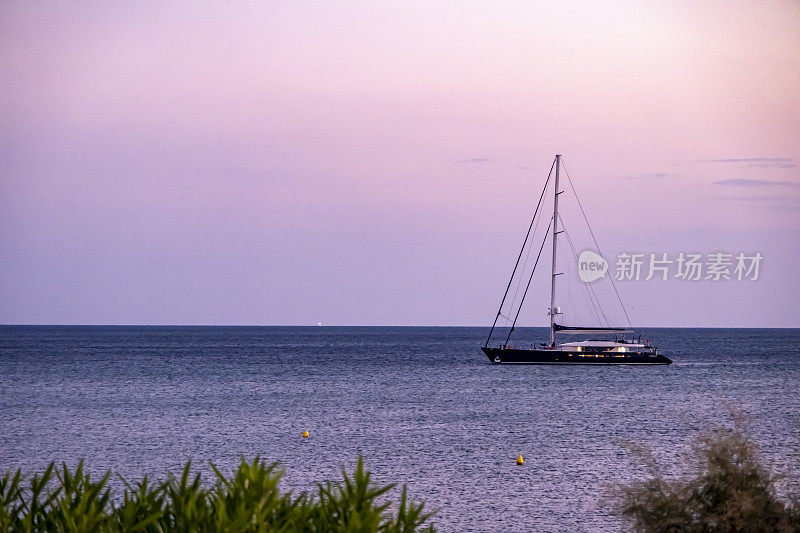 豪华帆船桅杆游艇停泊在美丽的大海和浪漫的天空背景