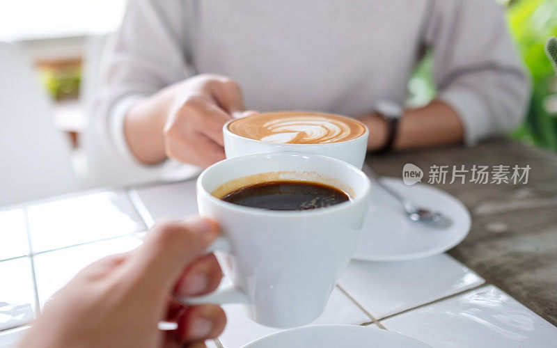 一对夫妇在咖啡馆里碰咖啡杯的特写照片