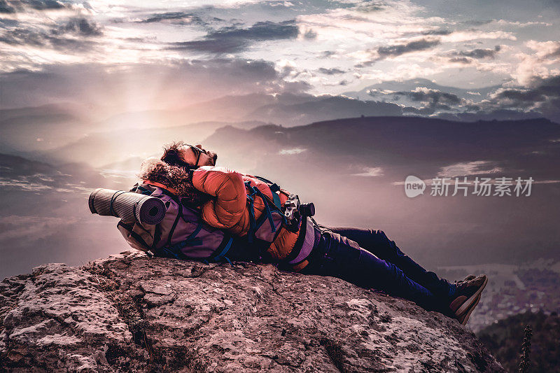 徒步旅行者在山顶欣赏云景，实现了梦想。