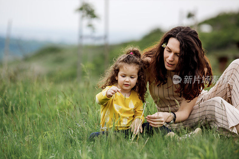 母女俩在户外玩耍，开心地笑着